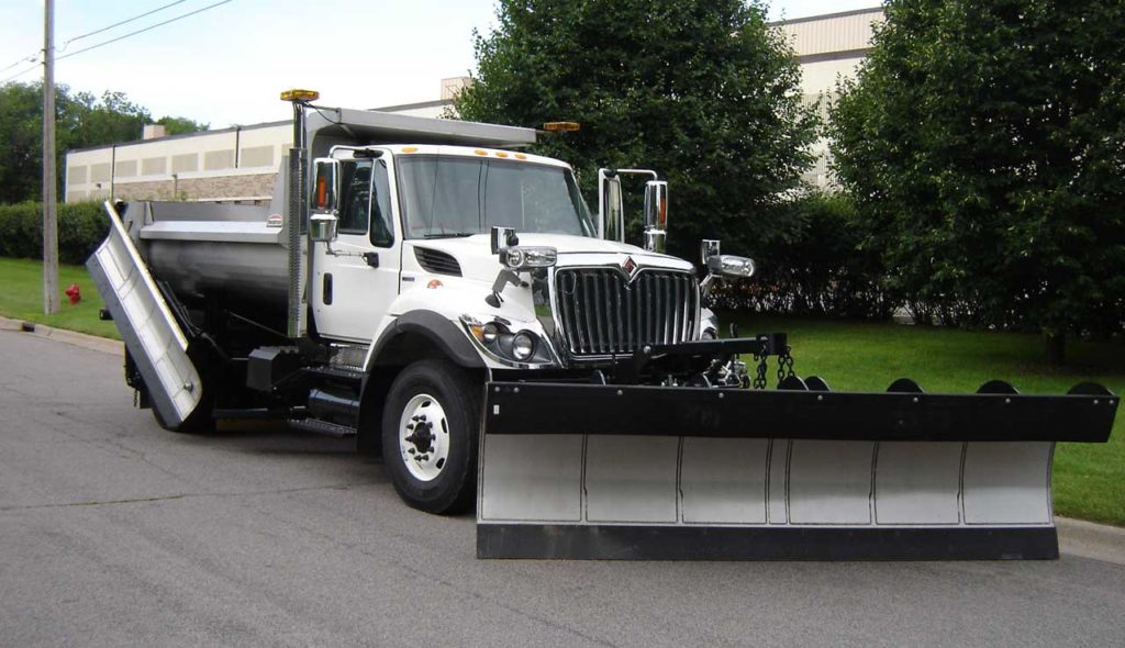 Henderson single axle snow plow truck with stainless steel body, spreader, wing, and snow plow.