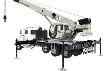 Boom truck crane with tri-axle and extended outriggers