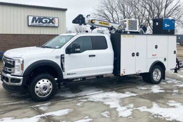 White mechanics truck with Ford F550 SuperDuty extended cab and mechanics body with service crane and welder unit on top parked in front of an MGX Equipment Services building