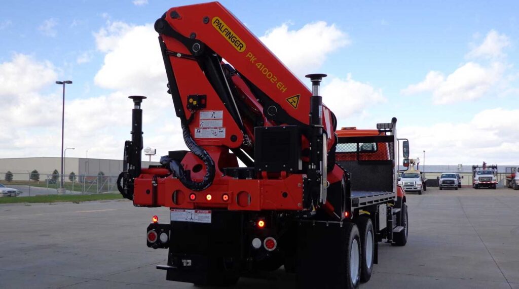 View of Palfinger PK articulating crane rear mounted on a dual axle flatbed truck
