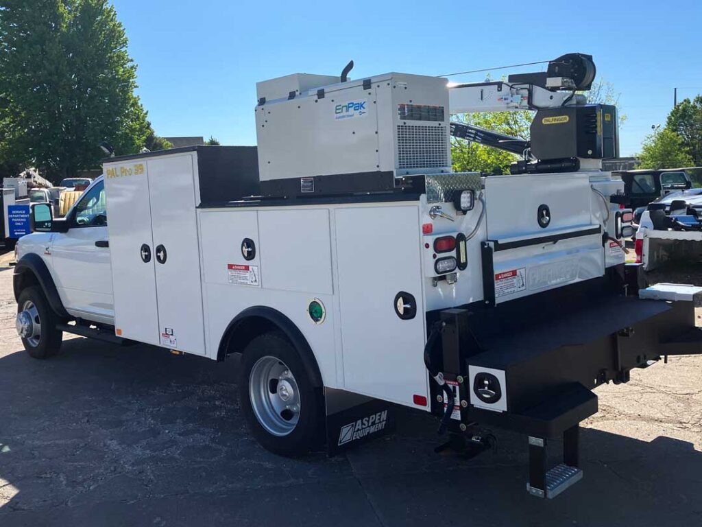 Individual wearing high visibility gear using a power tool with a hose leading to a single-axle trailer connected to a portable power air compressor with Doosan and P425 HP375 branding on the side.