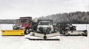 Line-up of Fisher brand snow plows on a snowy surface.