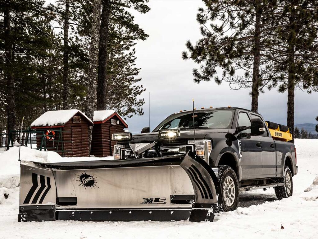 UTV with FISHER poly tailgate spreader driving on a walking path.