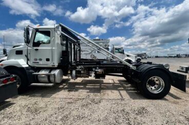 Mack MD7 chassis truck upfitted with SwapLoader hooklift system parked under blue skies for heavy-duty commercial use in construction, waste, and municipal fleets.