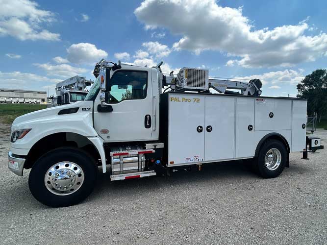 White commercial truck with PAL Pro 72 mechanics body parked outdoors on gravel. Compressor and service crane mounted on service body.